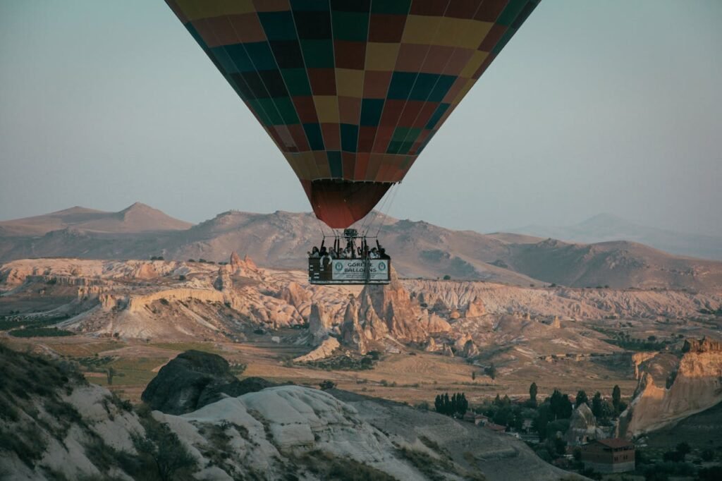 Scenic view of a vibrant hot air balloon floating over the unique geological formations in Cappadocia.